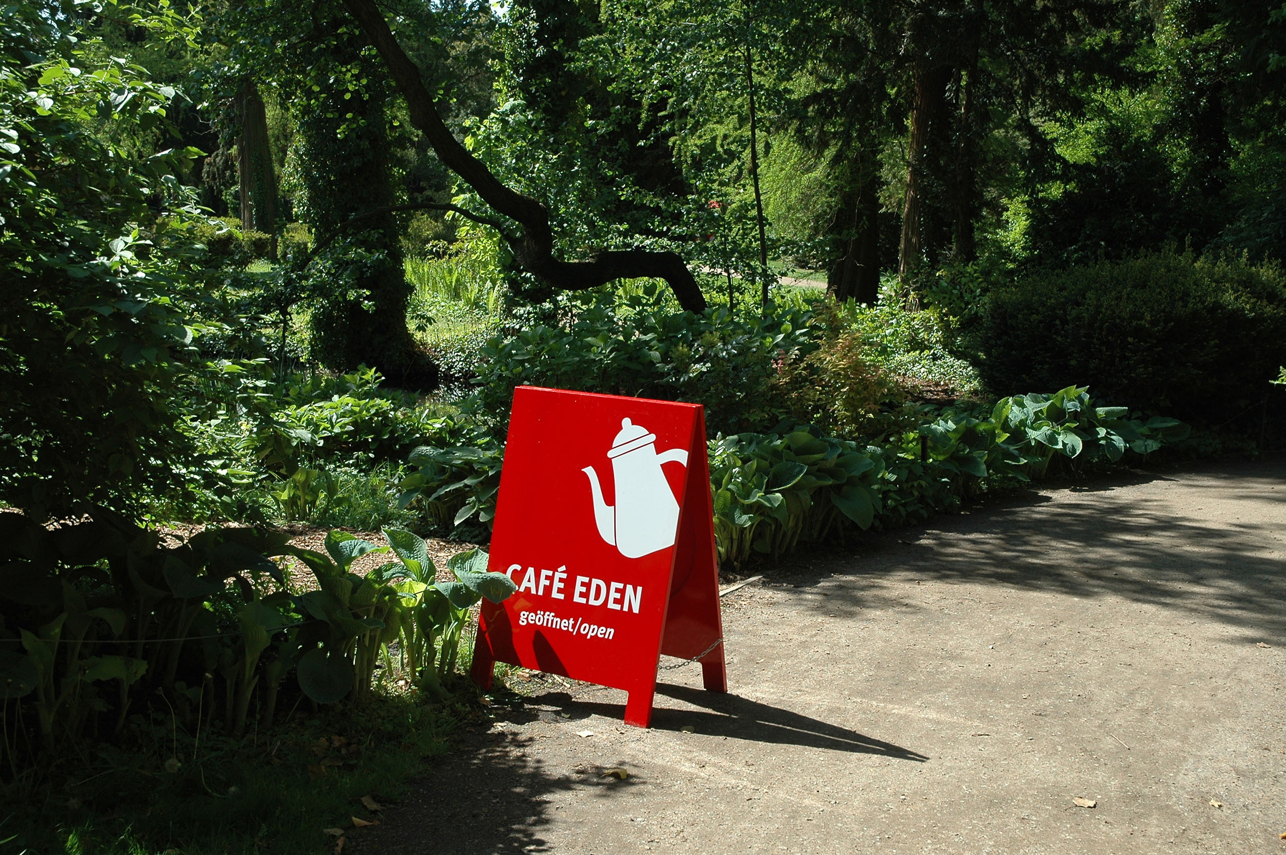 Eine Wegeleitschild zum Café Eden im Park Sanssouci im Look der Outdoorausstellung Paradiesapfel.