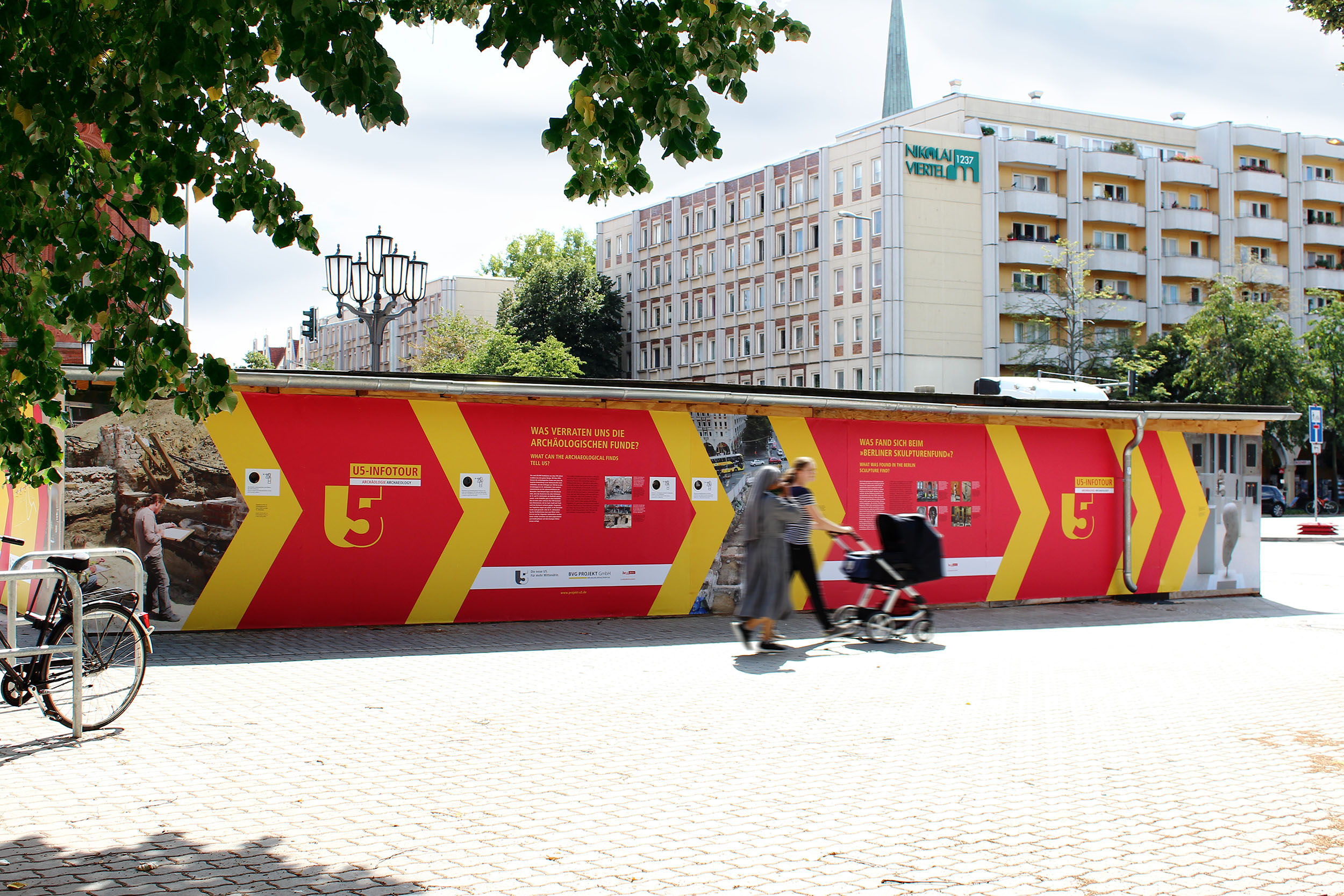 U5 Infotour mit gelb roter Wand zum Baufortschritt der U5 in Berlin Mitte.